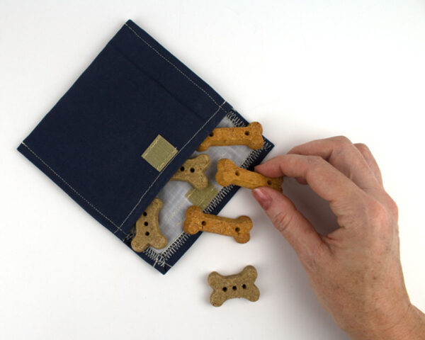 Treat Pouch open with treats and hand navy