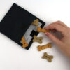 Treat pouch open with treats and hand black